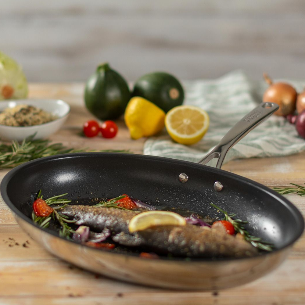 Tigaie pentru peste Kuhn Rikon, Allround, 36x25 cm, ideala pentru gatit peste intreg si fileuri, otel inoxidabil, 3 straturi antiaderente, distribuire uniforma a caldurii, compatibila cu toate sursele de caldura, inox, tigaie pusa pe masa